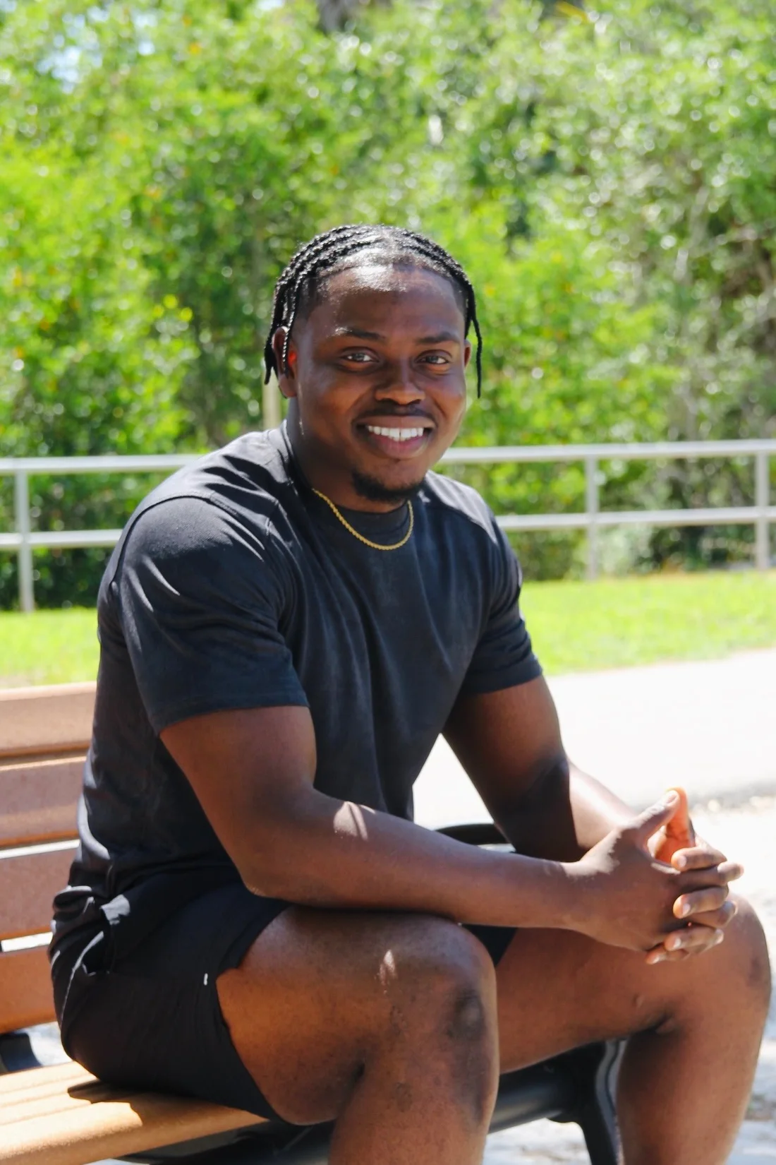 Person smiling while seated outdoors